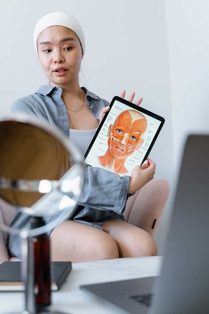 pexels photo 8076067 Young woman explaining skin care using an anatomy chart on a tablet during a therapy session.